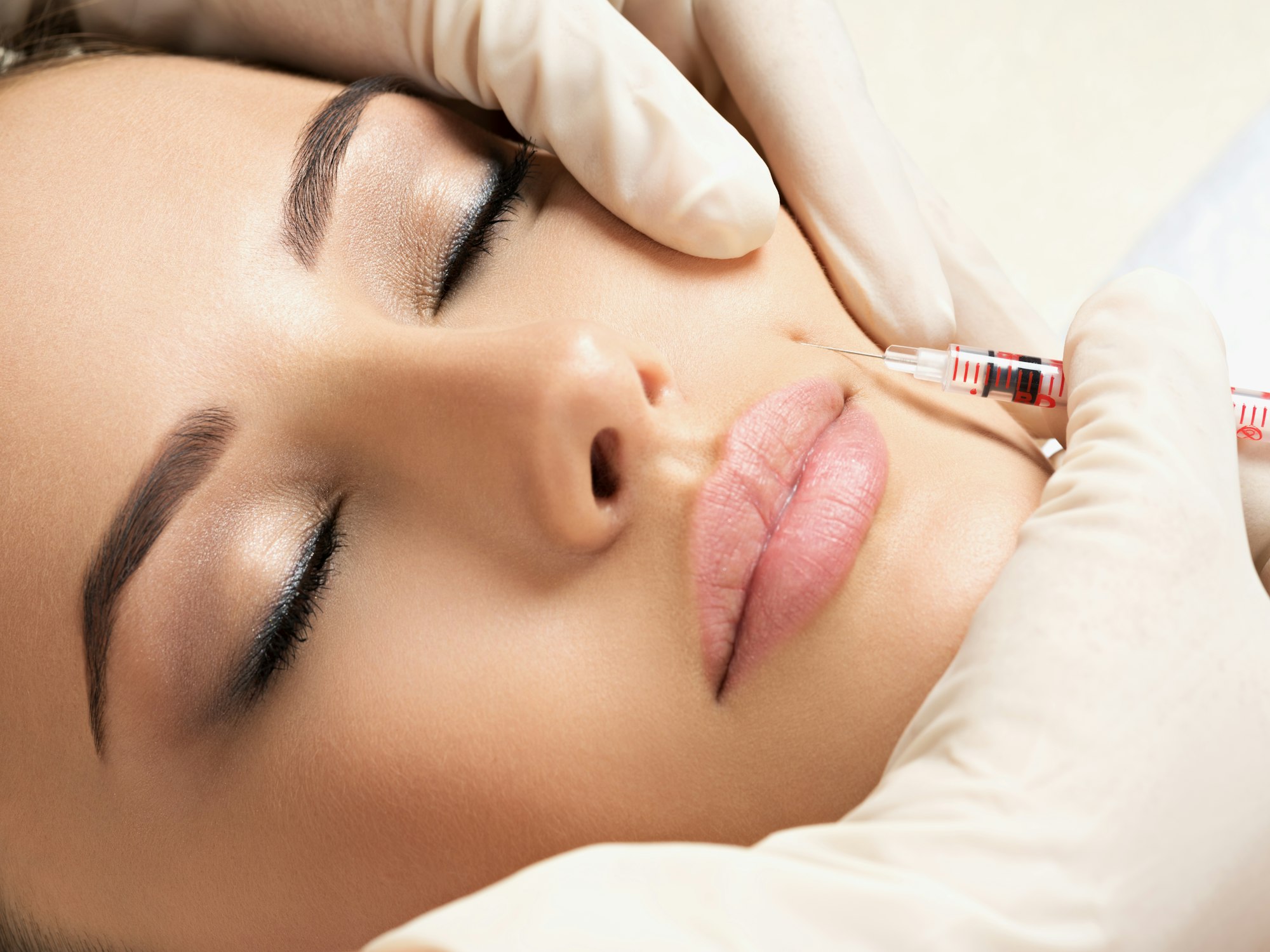 Aesthetic provider administering an anti-wrinkle injection to a relaxed client