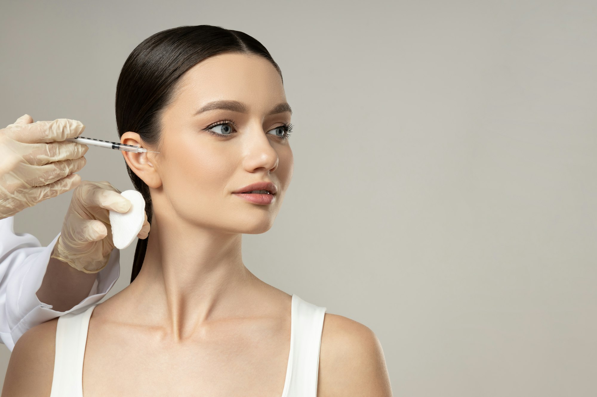 Provider carefully administering an anti-wrinkle injection to a client's forehead